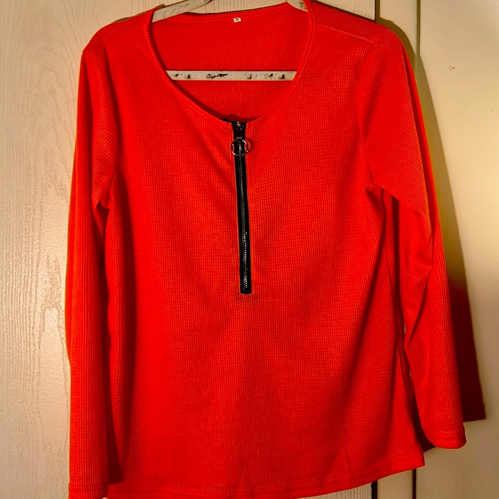 Ladies shirt that have a long black zipper in front never worn orange!